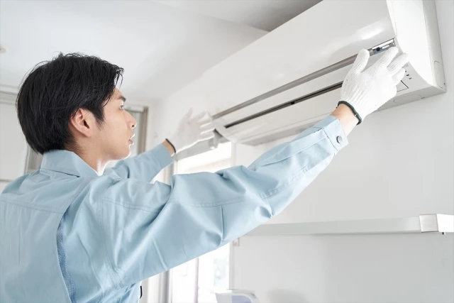 エアコンの室内機を取り付ける施工スタッフ