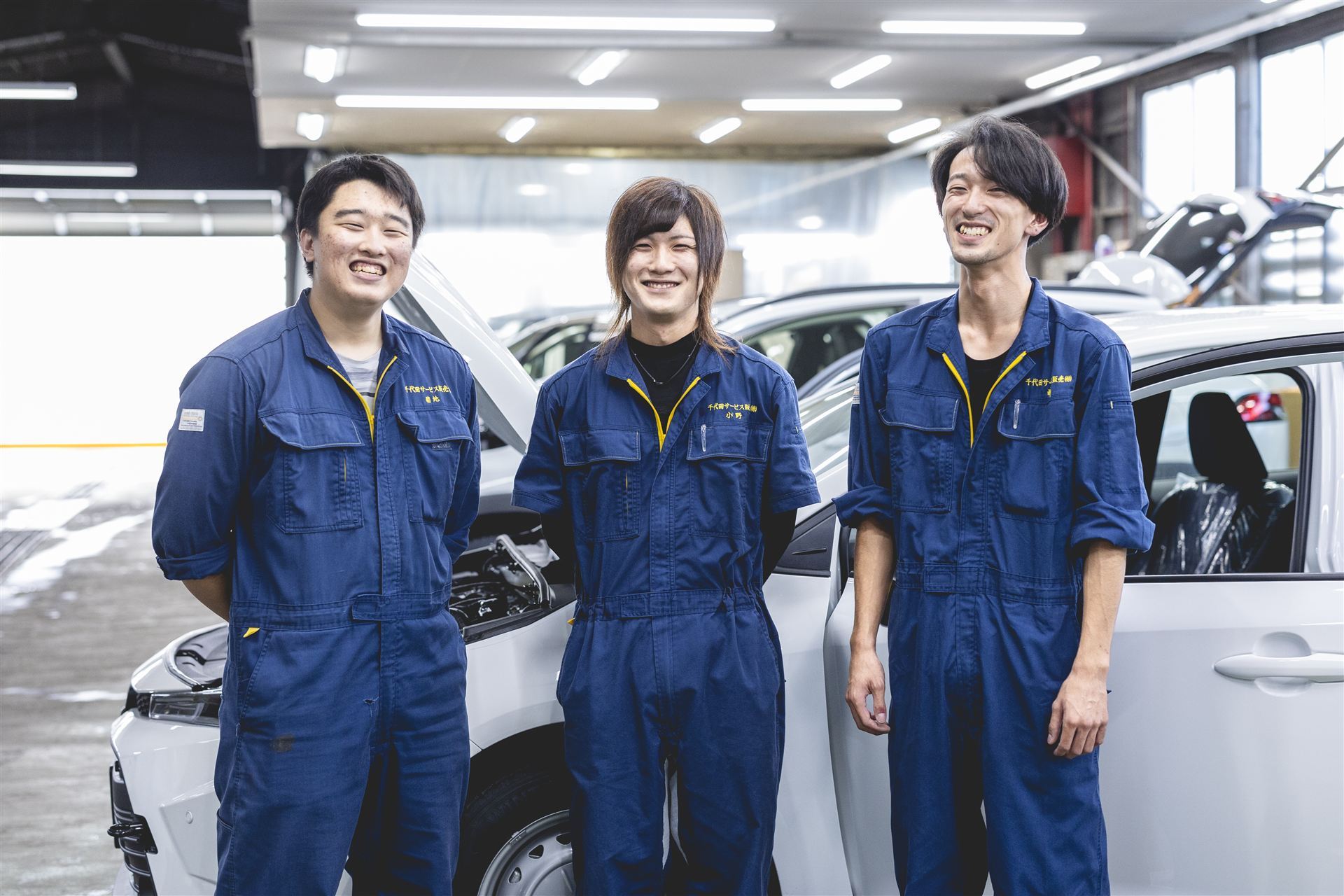 作業着姿で並ぶ社員3名