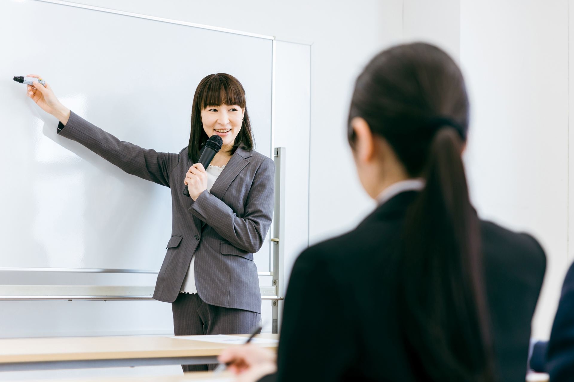 ホワイトボードの前で講義をする講師