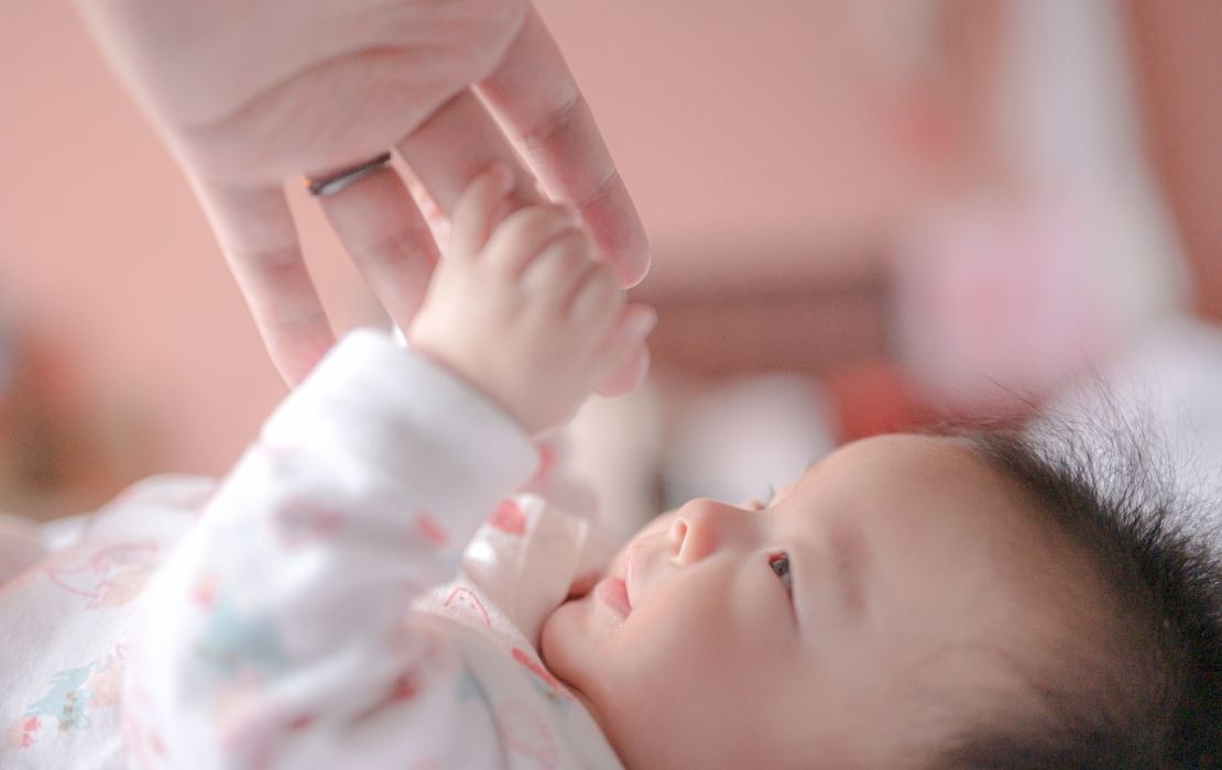 大人の指を握る赤ちゃん
