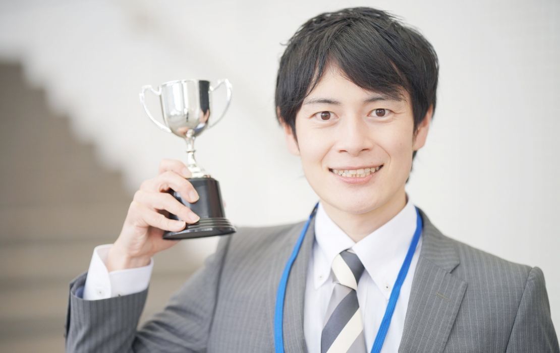 トロフィーを掲げる社員