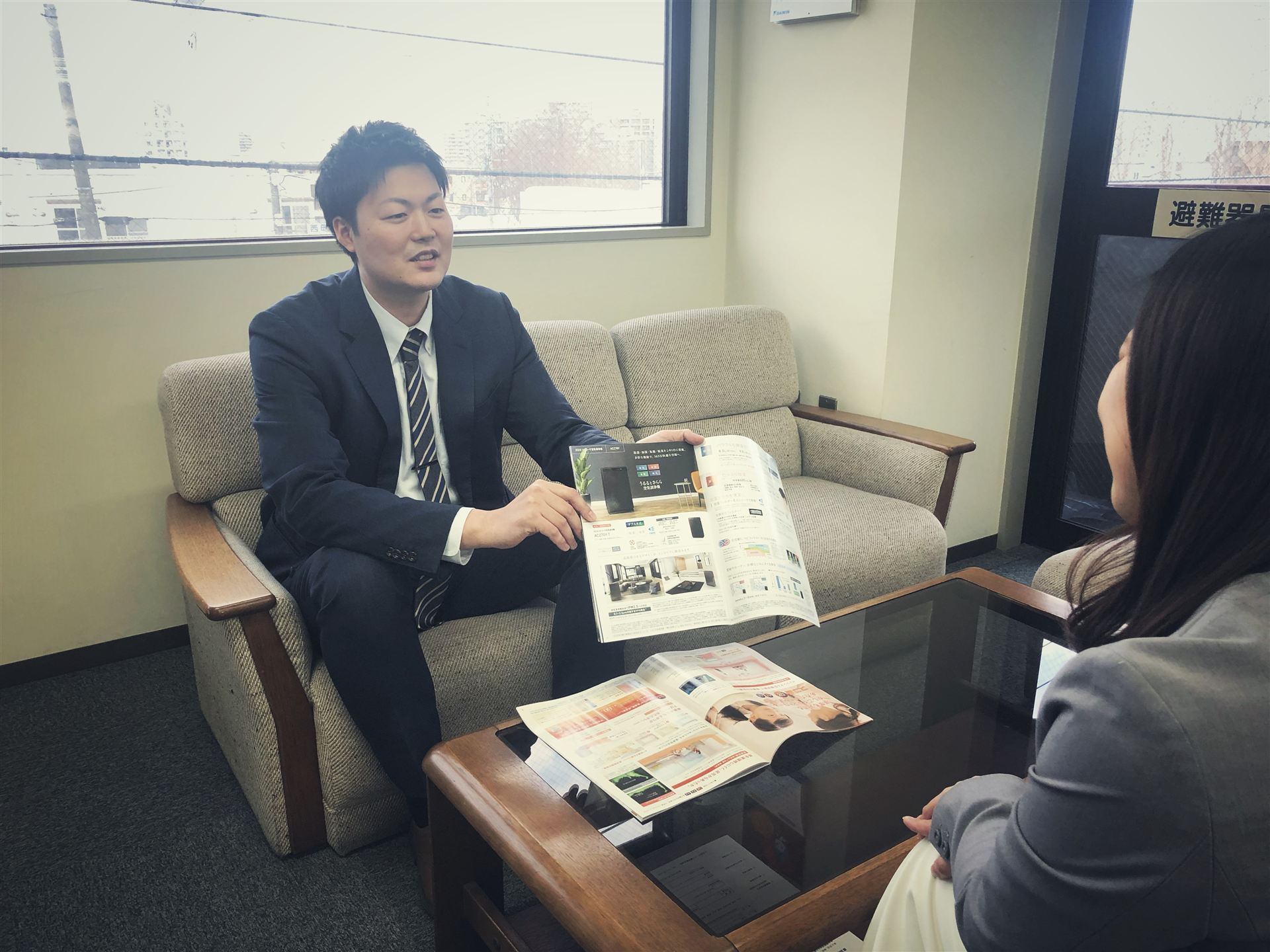 カタログを見せながらお客様に提案する営業担当者